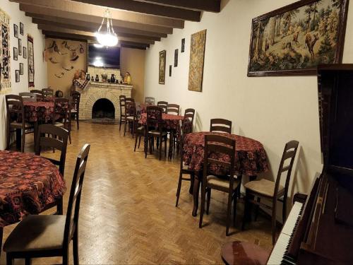 a dining room with tables and chairs and a fireplace at Guest House Tbilisi style in Tbilisi City