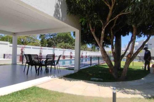 a table and chairs under a white canopy next to a tree at Apartamento top bem localizado in Vitória da Conquista
