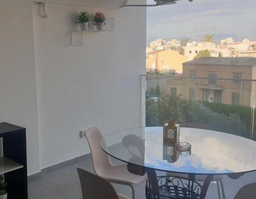 comedor con mesa de cristal y sillas en Deluxe 1 Bed Apt Ayios Dometios, en Ayios Dhometios