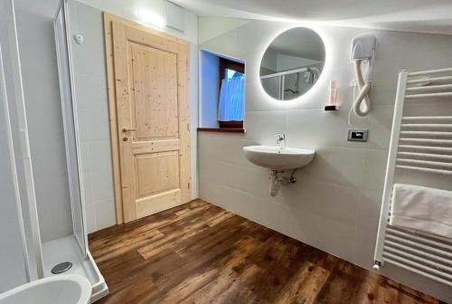 La salle de bains est pourvue d'un lavabo, de toilettes et d'un miroir. dans l'établissement Ski Lodge Pampeago, à Tesero