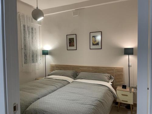 um quarto com 2 camas, uma secretária e 2 candeeiros. em Amplio en el corazón d Malasaña em Madri