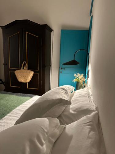 ARCHIVIO MANZONI 37 في كريمونا: غرفة نوم بسرير ذو شراشف بيضاء وباب ازرق