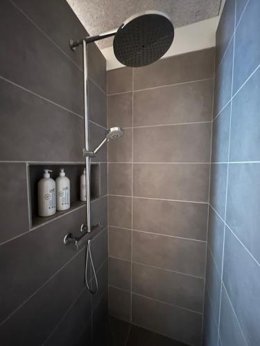 a shower with a shower head in a bathroom at Brand New Waterfront-Apartment in Hvalvík