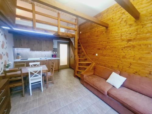 a living room with a couch and a wooden wall at Cihlářka - Liščí doupě 110 in Pec pod Sněžkou