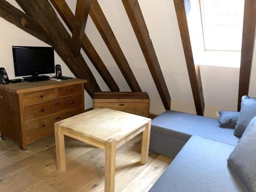 ein Wohnzimmer mit einer Couch, einem Fernseher und einem Tisch in der Unterkunft Küferhof Ferienhaus St Martin mit Sauna in Sankt Martin