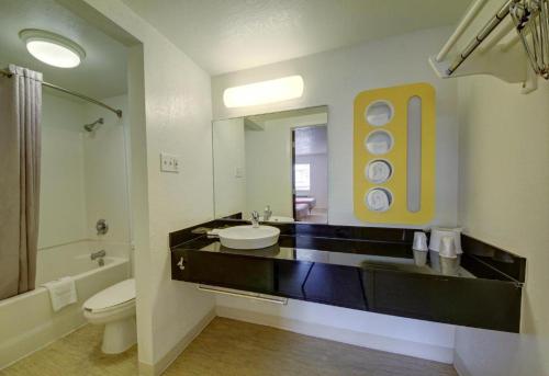 a bathroom with a sink and a toilet and a mirror at Motel 6 in Colorado Springs