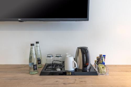 a counter top with a coffee maker and bottles on it at Premium Inn Mombasa City in Mombasa