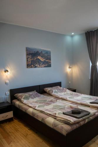 a bedroom with two beds and a painting on the wall at Къща за гости Белоградчик in Belogradchik