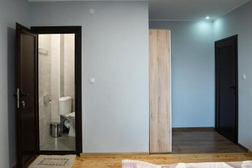 um quarto com uma casa de banho com um WC e uma porta em Къща за гости Белоградчик em Belogradchik