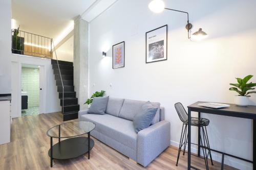 ein Wohnzimmer mit einem Sofa und einem Tisch in der Unterkunft Acacias Apartments - City Centre in Madrid