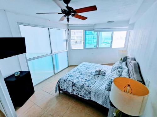 sypialnia z łóżkiem i wentylatorem sufitowym w obiekcie Punta Pacífica Oceanfront apartment w Panamie