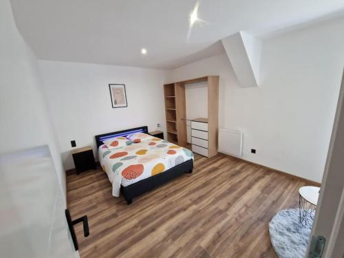 1 dormitorio blanco con 1 cama y suelo de madera en Gîte à 1,9 km du Mont St Michel, en Beauvoir