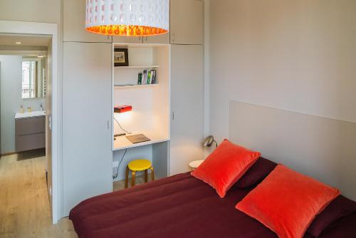 a living room with a couch with red pillows at Appartement 11 place d'Alliance in Nancy