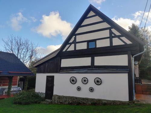a white and black building with clocks on it at West Bohemian Home, Krajkova 208 in Krajková