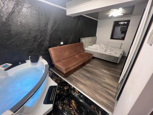 ein Badezimmer mit einem Sofa, einem Waschbecken und einer Badewanne in der Unterkunft Vila Rustik Straja in Lupeni