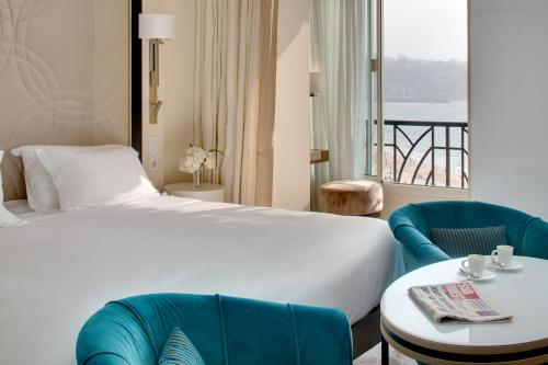 una camera d'albergo con letto, tavolo e sedie di Grand Hôtel Thalasso & Spa a Saint-Jean-de-Luz