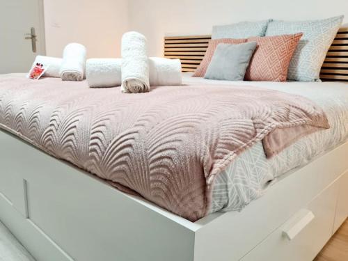 a large bed with a pink blanket on top of it at Meublé Flora pour voyageur pro - Centre, calme - Wi-Fi in Haguenau