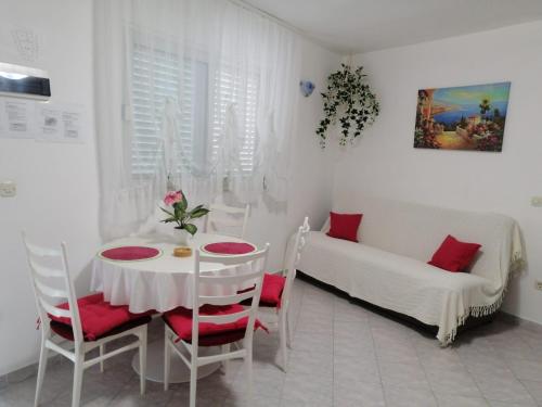 ein weißes Zimmer mit einem Tisch und einem Sofa in der Unterkunft Kuća za odmor Zdravka in Blato