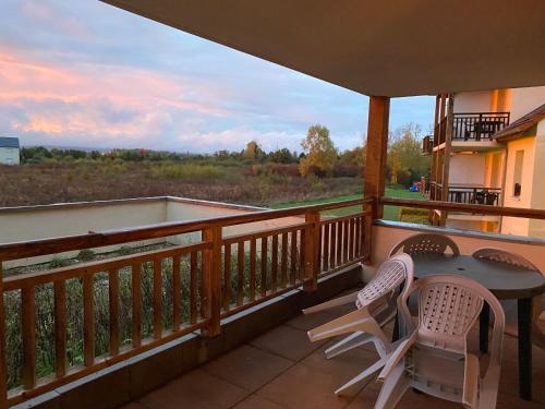 a balcony with a table and chairs and a view at Chez Suzette-Résidence-Piscine-Sauna in Levernois