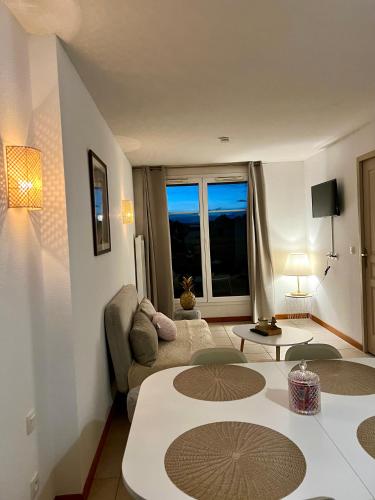 un salon avec un canapé et une table dans l'établissement Chez Suzette-Résidence-Piscine-Sauna, à Levernois