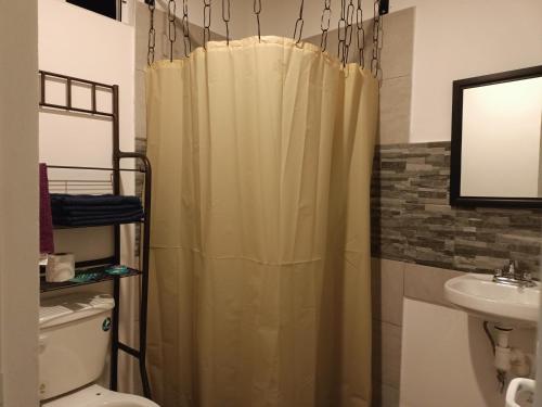 La salle de bains est pourvue d'un rideau de douche et d'un lavabo. dans l'établissement La cima, à Zacatlán