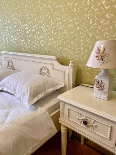 a bedroom with a bed and a table with a lamp at Downtown Apartment in Craiova