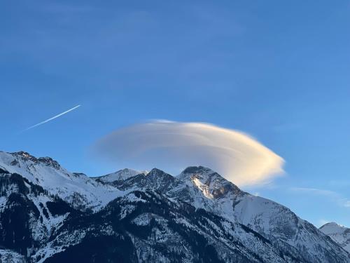 a lenticular cloud over a snow covered mountain at Select Apartment Top 13by Alpina in Piesendorf