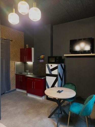 - une cuisine avec une table, une table et des chaises dans l'établissement Le Velvet, à Hénin-Beaumont