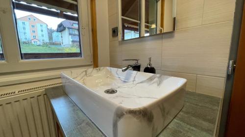 a white sink in a bathroom with a window at Lipno Pearl 2 in Lipno nad Vltavou