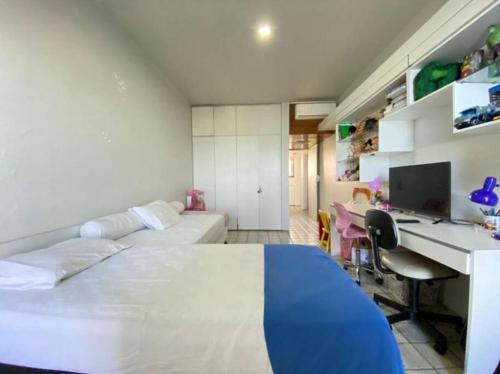- une chambre avec 2 lits, un bureau et un ordinateur dans l'établissement Apartamento Beira Mar em Recife, à Récife