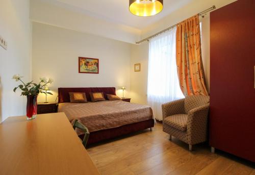 a bedroom with a bed and a chair and a table at Great Amber Apartment in Liepāja