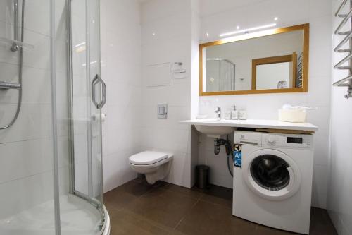 a bathroom with a toilet and a washing machine at Great Amber Apartment in Liepāja