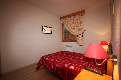- une chambre avec un lit rouge et une lampe rouge dans l'établissement Appartement résidence Montagne / ski Samoëns, à Samoëns