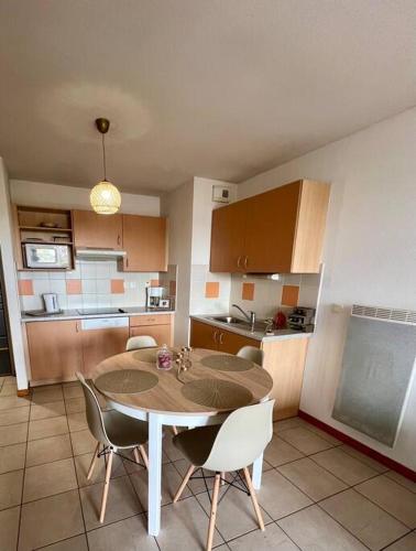 a kitchen with a table and chairs in a room at Chez Jack-Résidence-Piscine-Sauna in Levernois