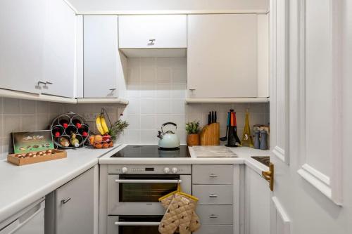 倫敦的住宿－Marylebone central apartment，厨房配有白色橱柜和炉灶烤箱。