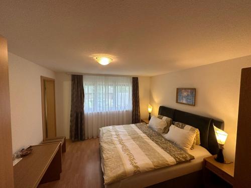 um quarto de hotel com uma cama e uma janela em Zimmer Mamma Mia em Bürchen
