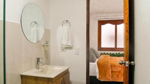 a bathroom with a sink and a mirror at OCASSO JARDIN APARTAMENTO TURPIAL in Jardin