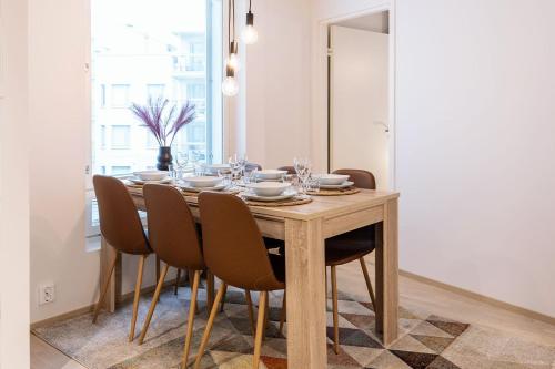 a dining room table with chairs and a dining room table at Stylish Scandinavian Suite - Sauna, Harbor & Free Parking in Helsinki