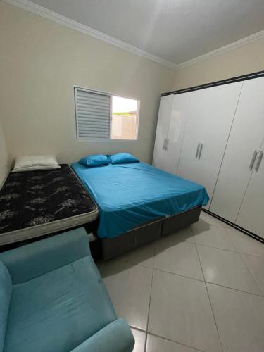 - une petite chambre avec un lit et une chaise dans l'établissement Casa com piscina em condomínio, à Cachoeira Paulista