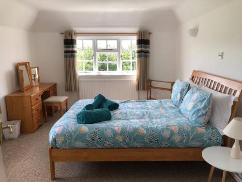 a bedroom with a bed with pillows and a window at Spacious character cottage overlooking fields in Harrietsham