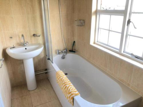 a bathroom with a sink and a bath tub and a sink at Spacious character cottage overlooking fields in Harrietsham