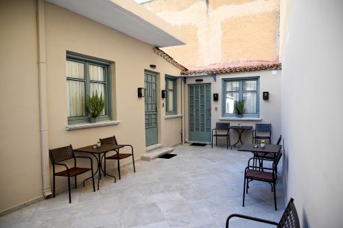 a patio with tables and chairs and windows at ΜΕΛΑΝΘΙΑ m2 in Preveza