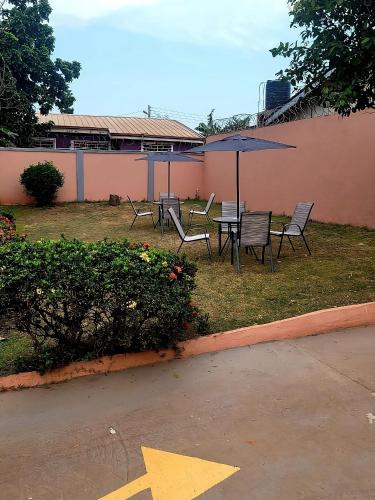 a table and chairs with an umbrella in a yard at GHouse in Adentan