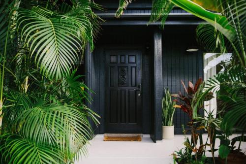 una puerta negra de una casa con plantas en Magic Sands Beach Bungalow, en Kailua-Kona