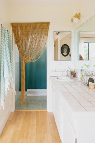 a bathroom with a tree in the middle of it at Magic Sands Beach Bungalow in Kailua-Kona
