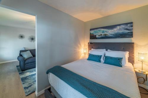 ein Schlafzimmer mit einem großen Bett mit blauen Kissen in der Unterkunft Tiny Treasure in St Pete Beach