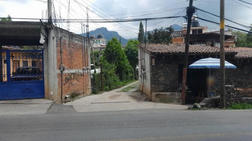 an empty street with a building with a blue umbrella at Hospedaje Casa Cortés - Recamaras de Descanso, Tepoztlán Mor - NO CONTAMOS CON ESTACIONAMIENTO in Tepoztlán
