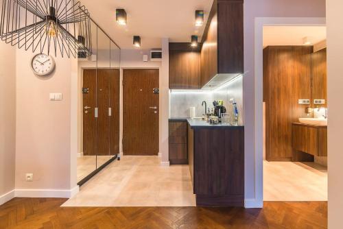 a kitchen with wooden cabinets and a clock on the wall at Rent like home - Bruna 2 in Warsaw