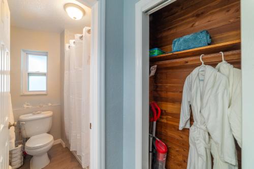 ein Bad mit einem WC und einer Holzwand in der Unterkunft Tiny Treasure in St Pete Beach