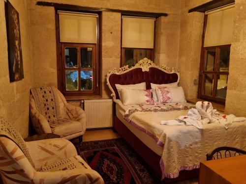 a bedroom with a bed and a chair and windows at Born Hotel in Urgup